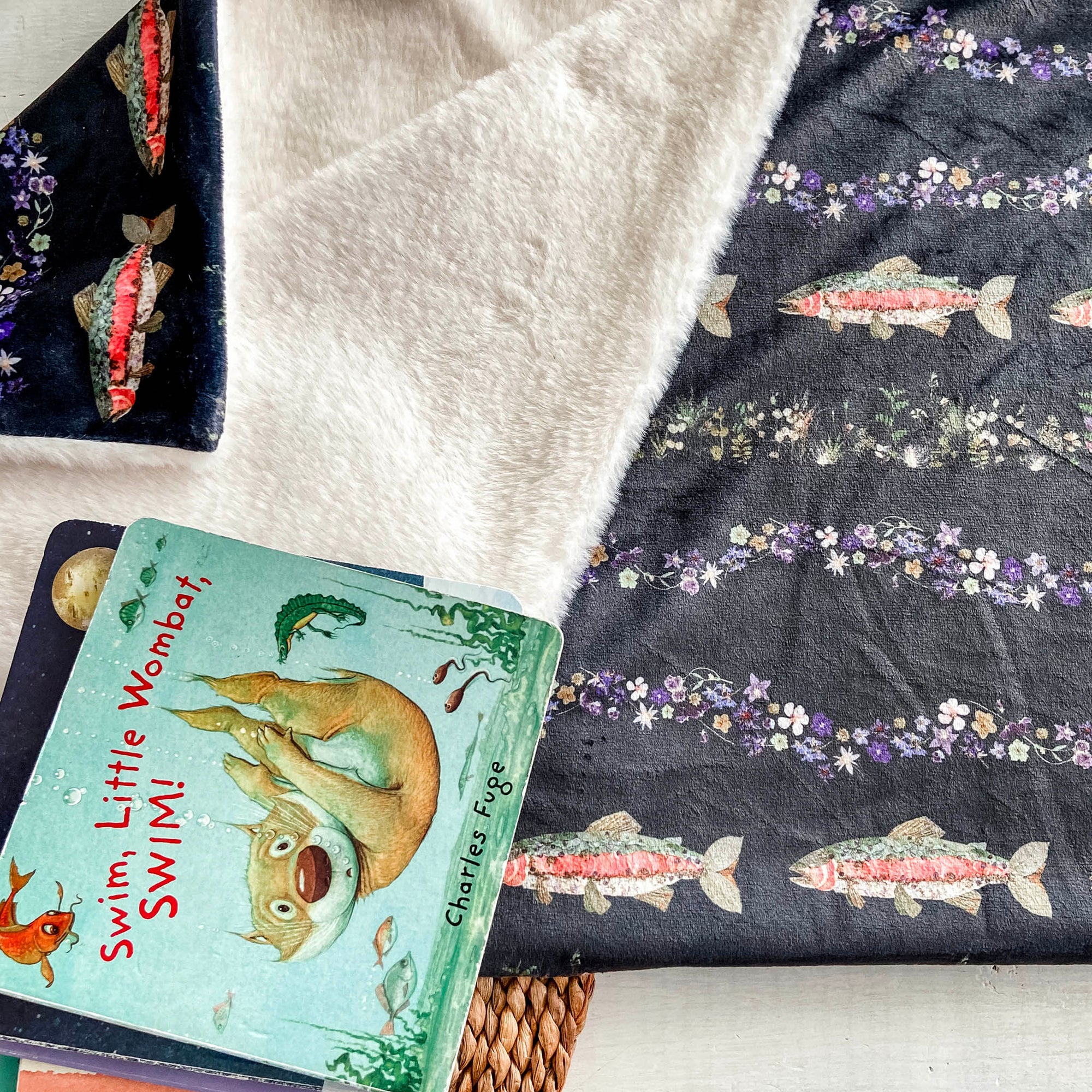Floral Baby Blanket with Fish Print displayed with baby books