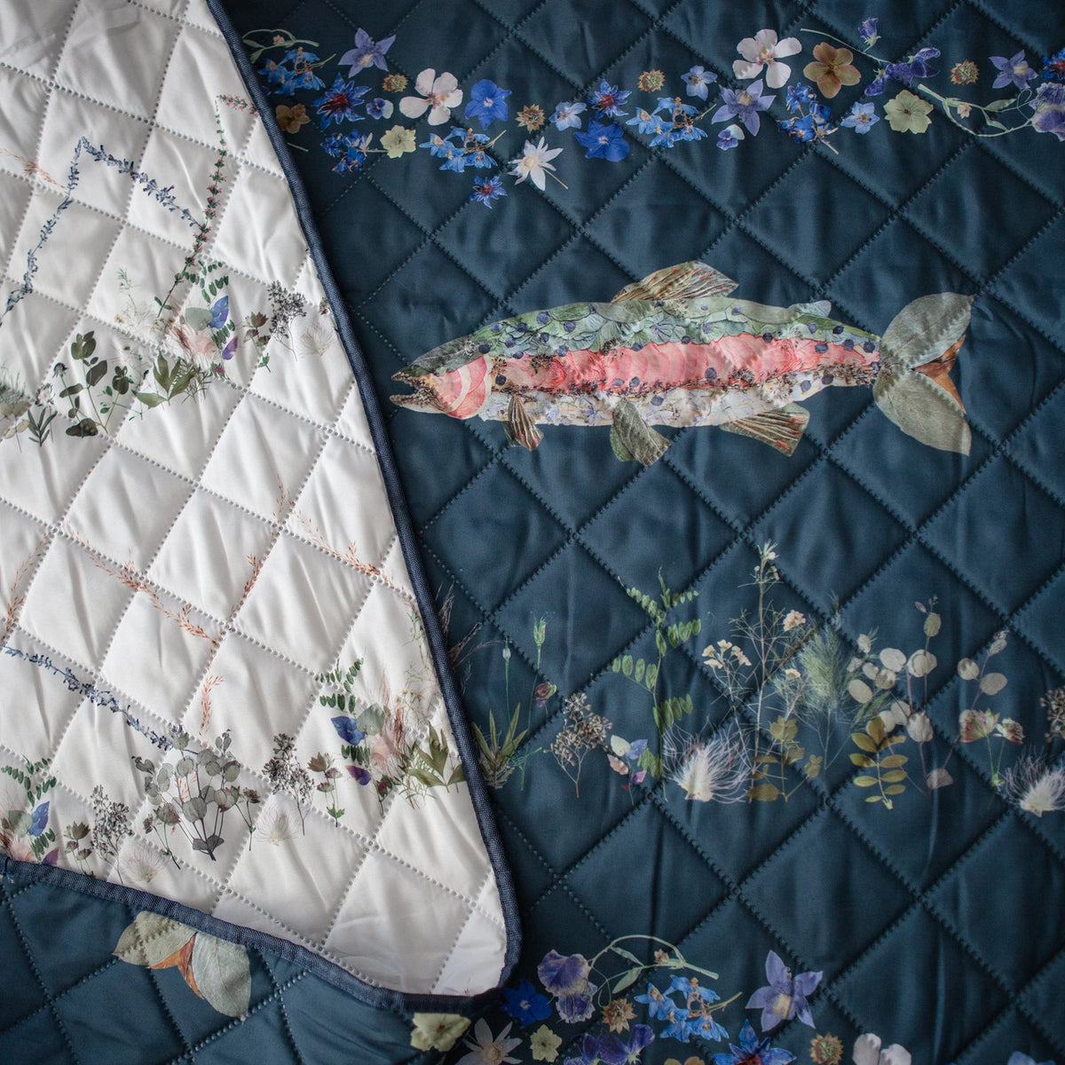 Quilted Outdoor blanket with fish and floral patterns on turquoise background