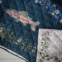 Double-sided picnic blanket with floral trout design on a turquoise background