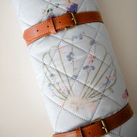 Coastal Drift Voyager Blanket by Oxeye Floral Co, rolled up with faux leather handle