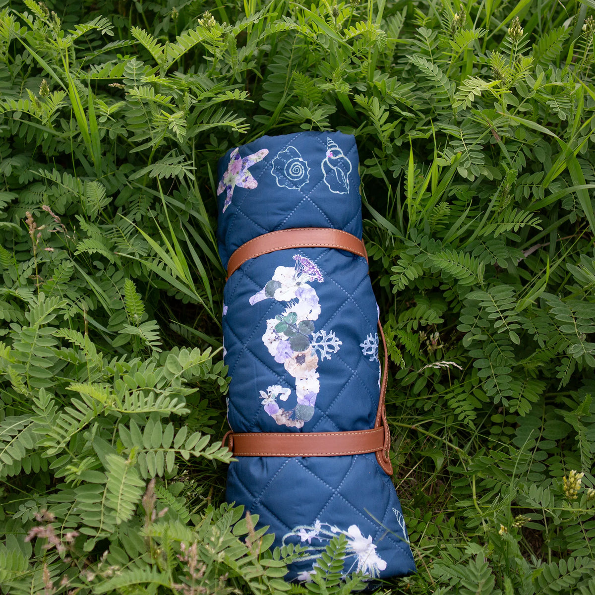 Rolled up outdoor blanket by Oxeye Floral Co with carrying handle