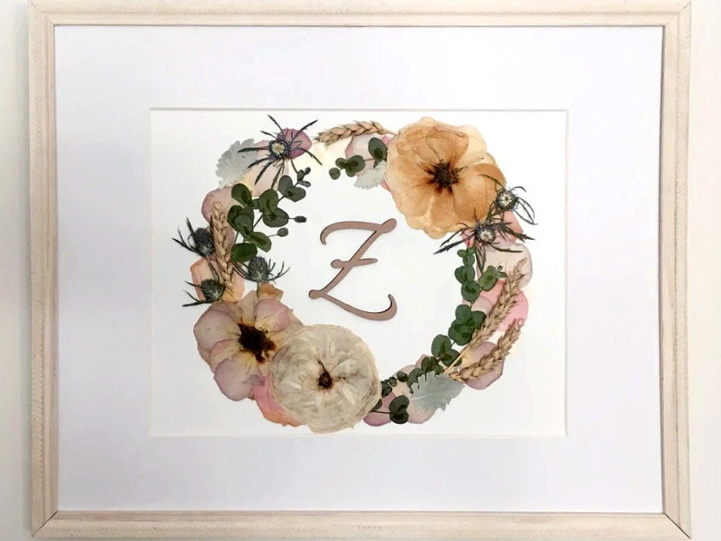 preserved wedding flowers arranged in a wreath with initials in the center