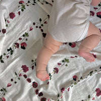 Pressed flower ladybug design on a cotton muslin swaddle