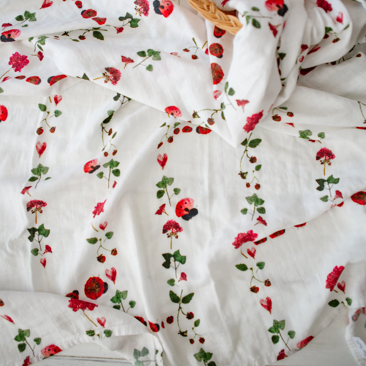 White muslin swaddle with ladybug design