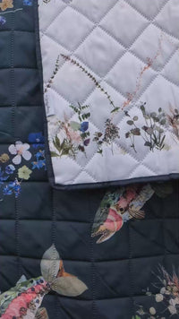 Close up of a beautiful pressed flower design on a river-themed outdoor blanket