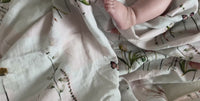 Baby feet on a pressed flower infant swaddle