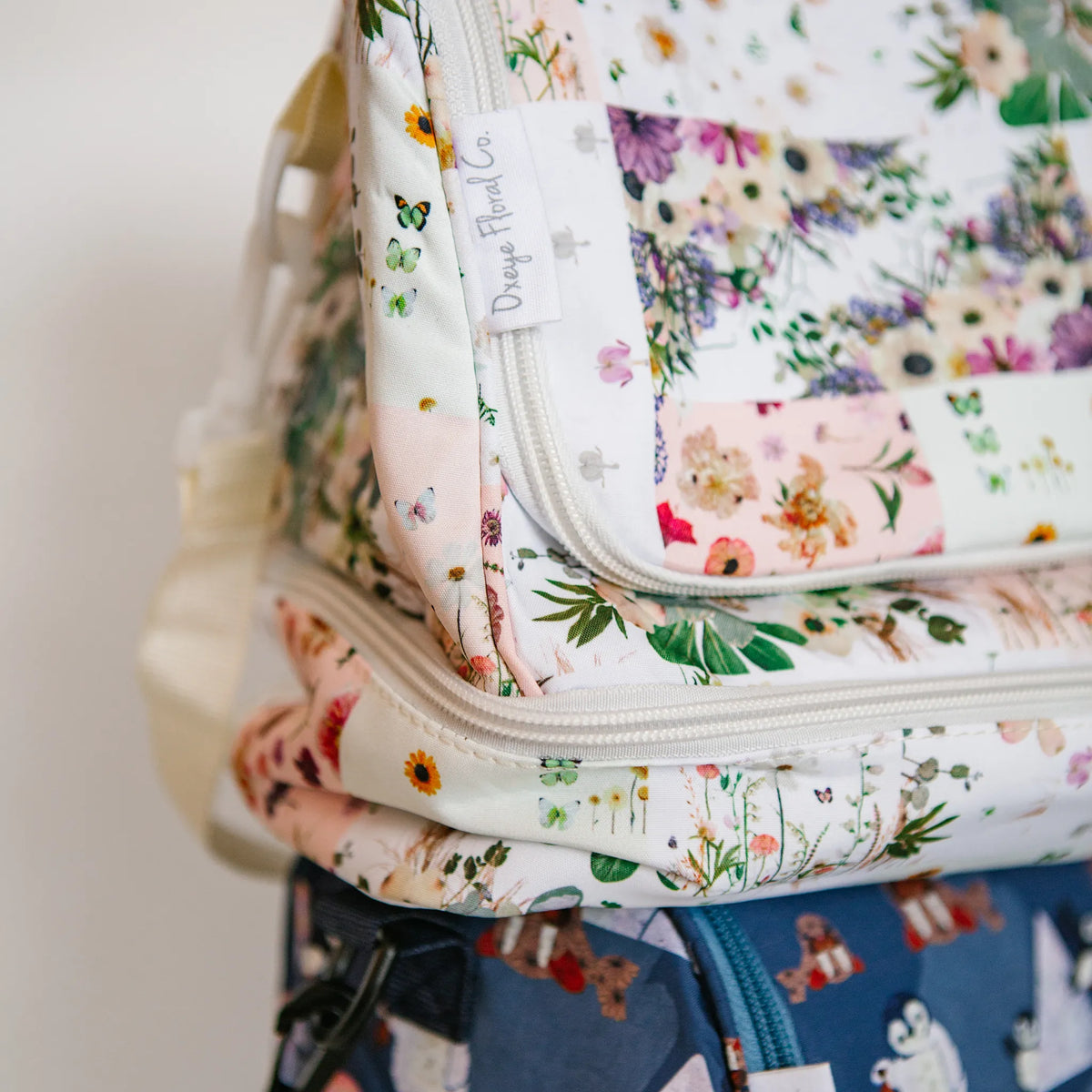 Floral-patterned insulated lunch bag with a visible Oxeye Floral Co brand label on a neutral background