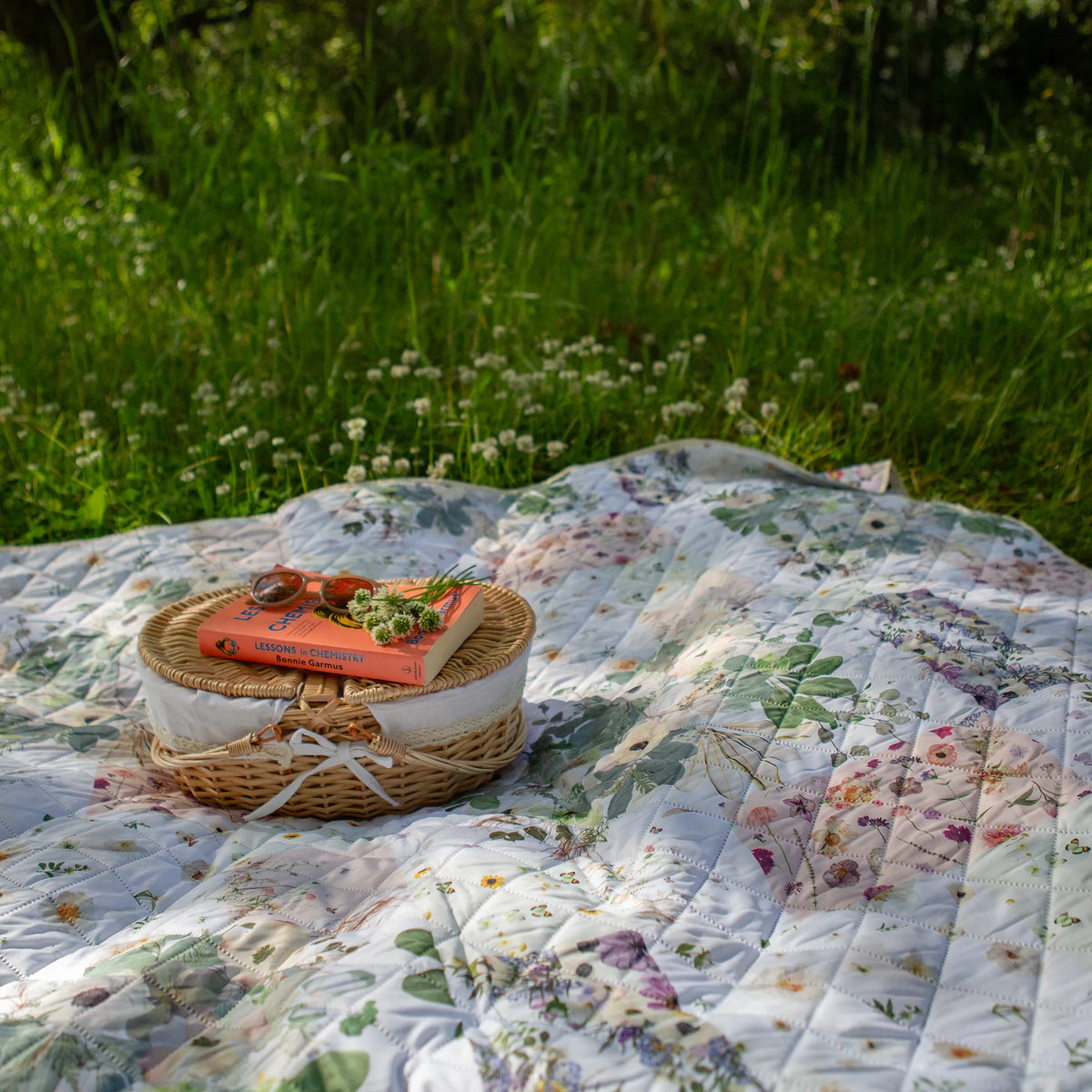 Verona Voyager Blanket used as a picnic blanket in a grassy clover field