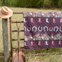 western theme outdoor blanket with pressed flower designs on a farm gate