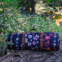 Floral-patterned rolled up blanket on a tree stump with a natural background