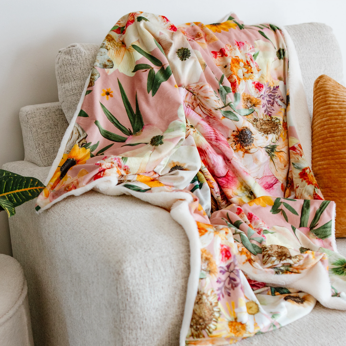 Pressed Flower Peaches and Sunshine blanket on a cream coloured couch