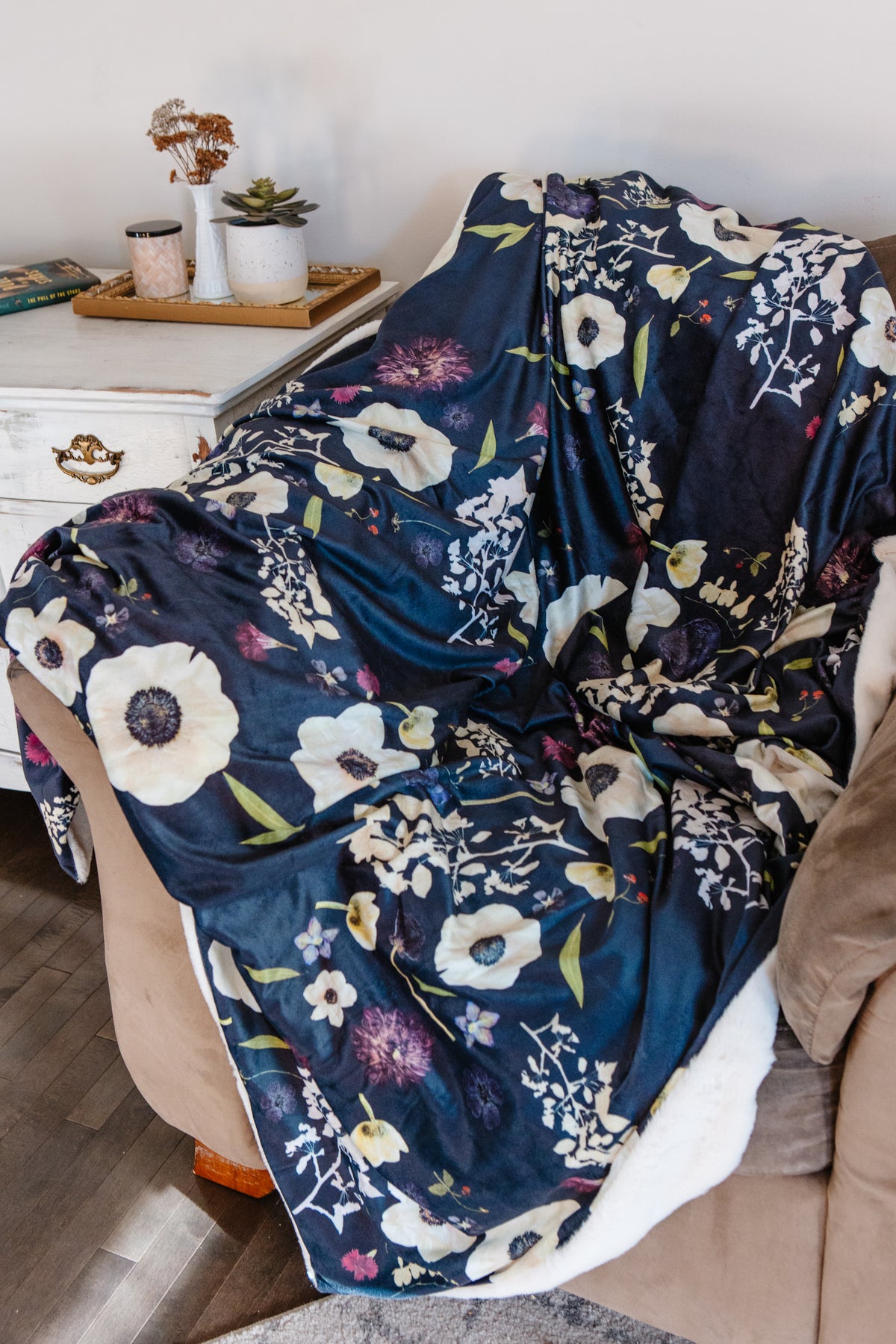 Floral-patterned blanket draped over a chair in a cozy living room setting.