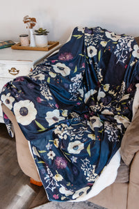 Floral-patterned blanket draped over a chair in a cozy living room setting.