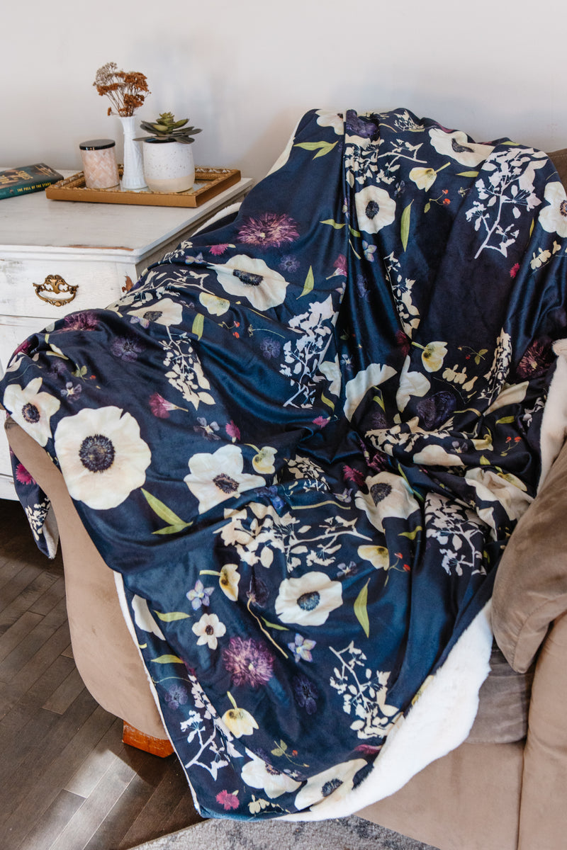 Floral-patterned blanket draped over a chair in a cozy living room setting.