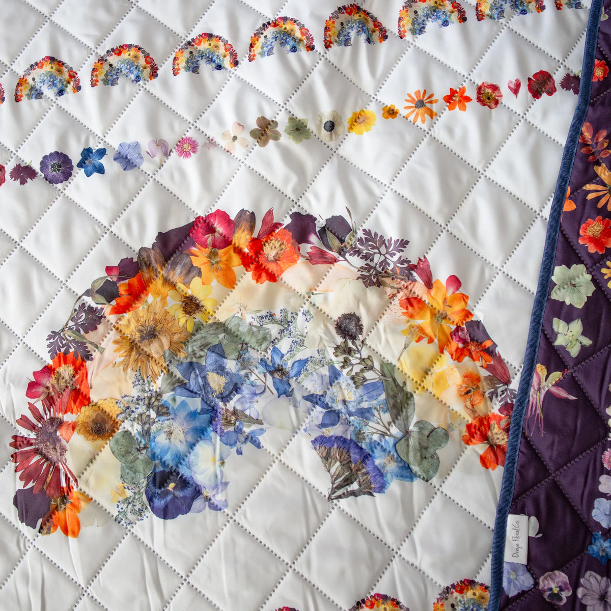 Picnic Blanket with floral patterns and rainbow designs on a white background