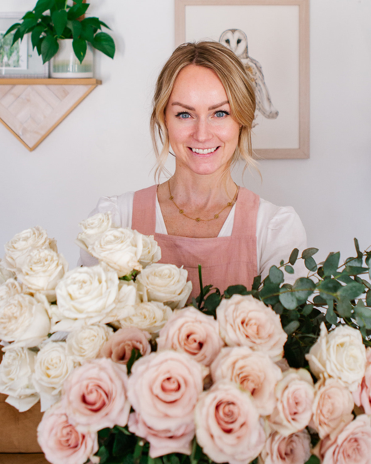 Oxeye Floral Co's Ayla Graham holding a bouquet of roses