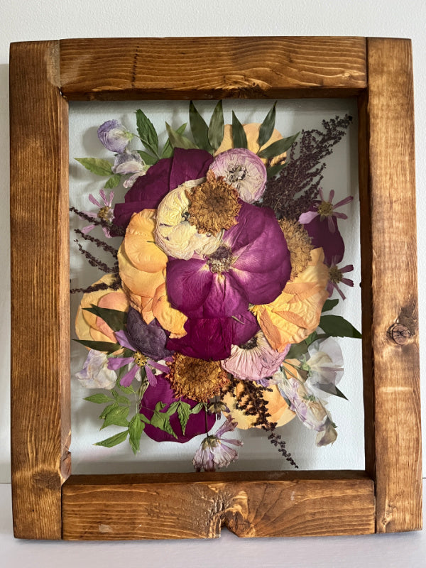 Purple and peach bright pressed flowers in a wooden frame by Oxeye Floral Co