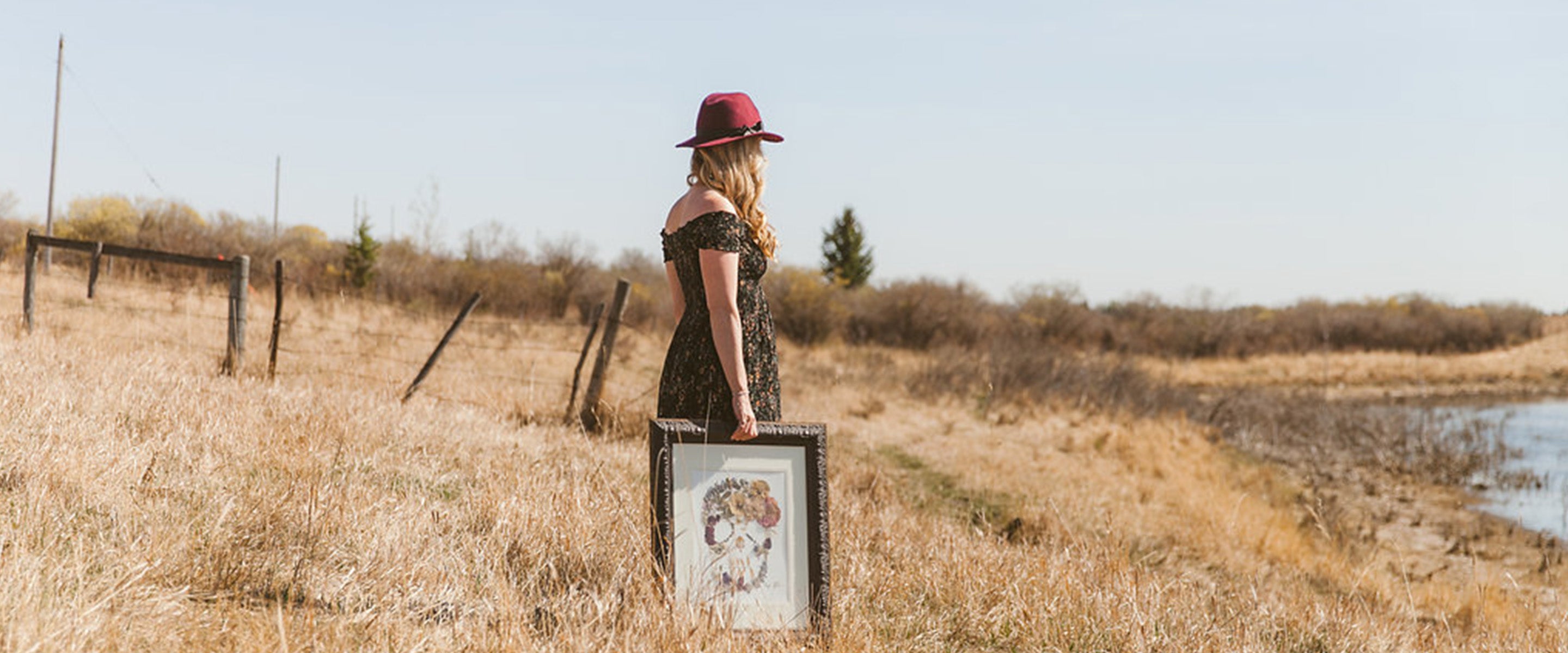 pressed flower artist holding an original art piece