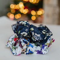 Floral scrunchies on a surface with blurred lights in the background