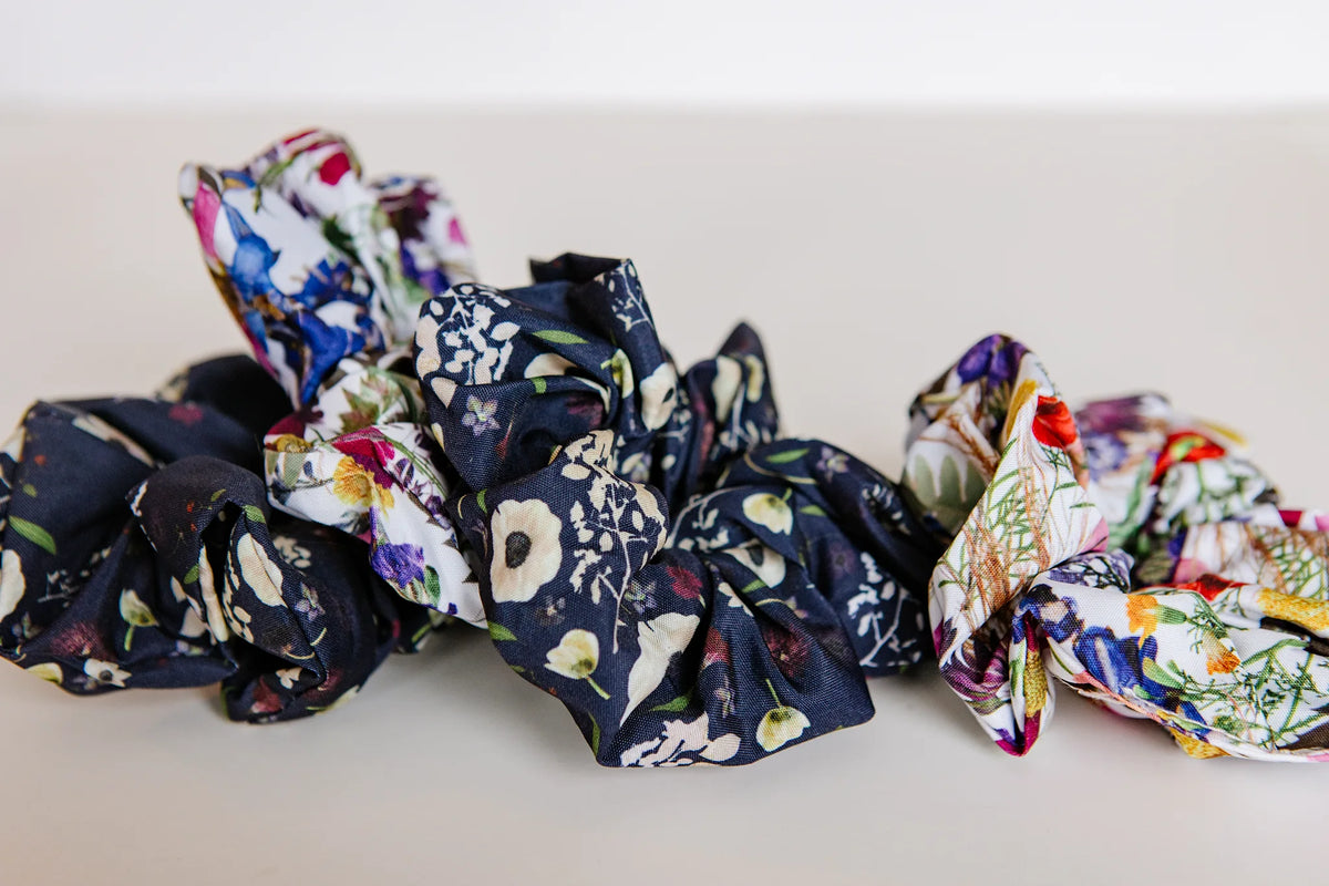 Set of floral and patterned scrunchies on a white surface