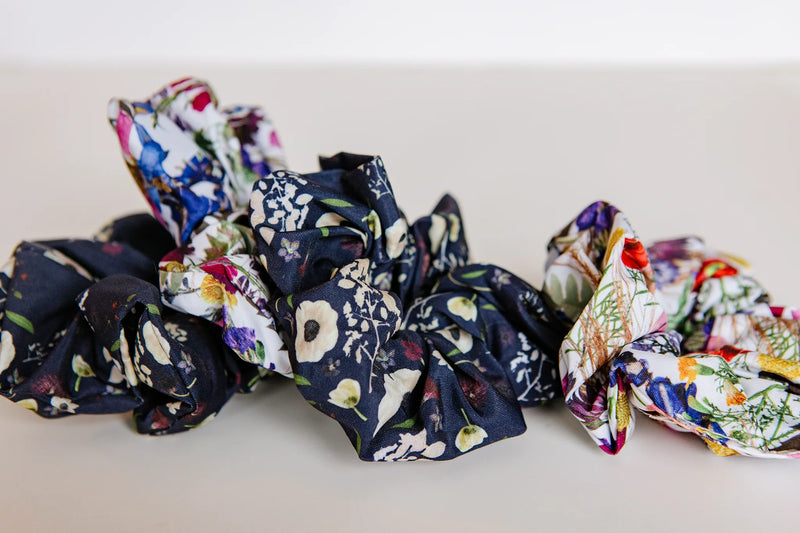 Set of floral and patterned scrunchies on a white surface