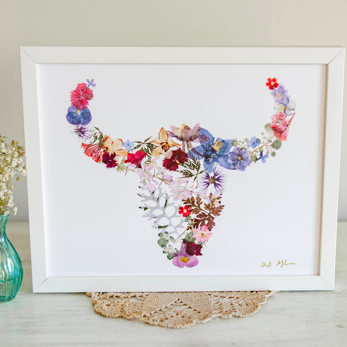 Framed buffalo floral art piece on a white surface with a neutral background