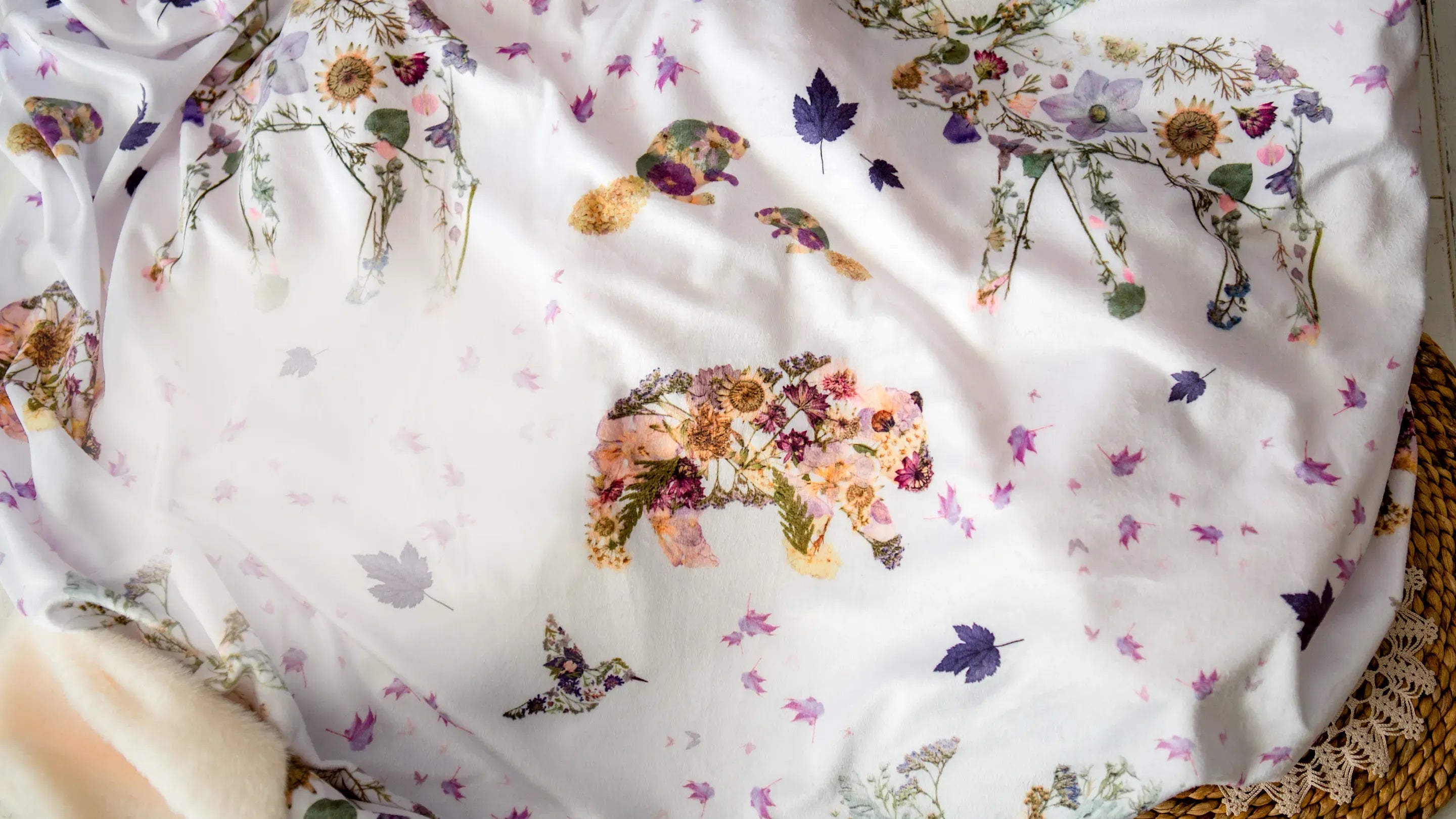 Floral-patterned fabric with bears, beavers and moose on a white background