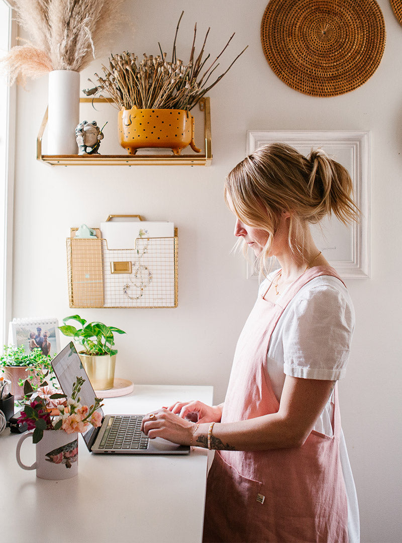 Woman typing at a computer in a flower studio