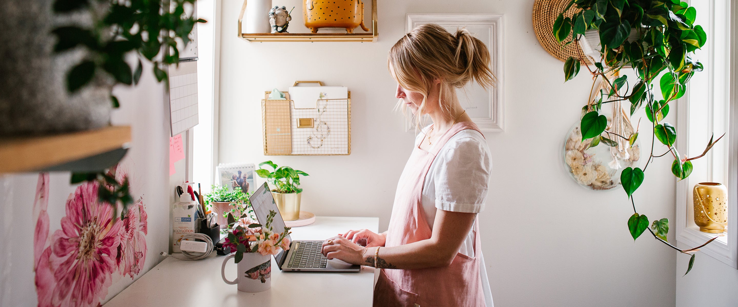 Woman typing at a computer in a flower studio