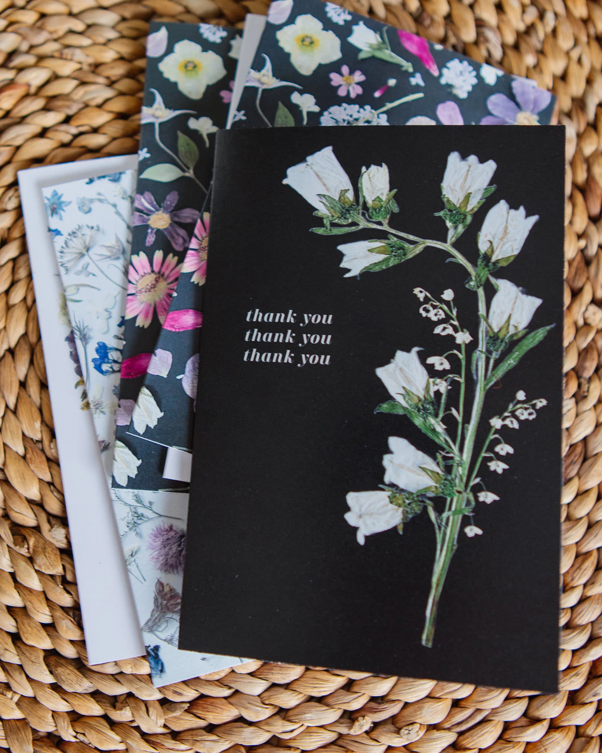 Set of greeting cards with floral designs on a woven surface