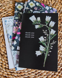 Set of greeting cards with floral designs on a woven surface