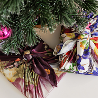 Two gifts under a Christmas Tree wrapped in faux silk wrap with floral designs
