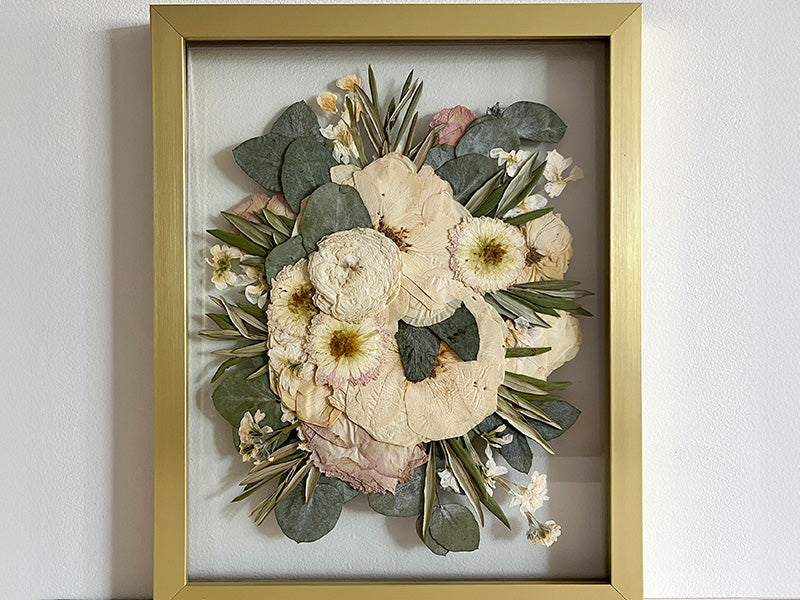 Warm neutral color pressed flowers in a gold frame