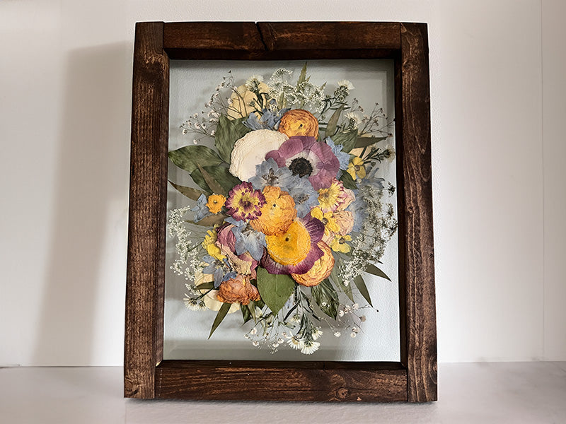 bright colour bouquet of pressed flowers arranged in a frame