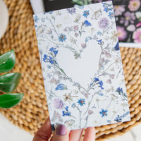 Floral heart-shaped greeting card being held