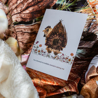 Card with floral design and text on a matching throw blanket