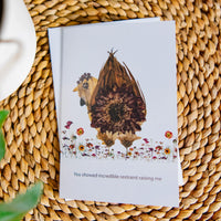 Greeting card with whimsical chicken design and text on a woven surface