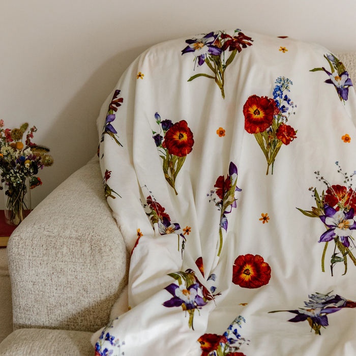 Throw blanket with floral bouquet design on a beige couch