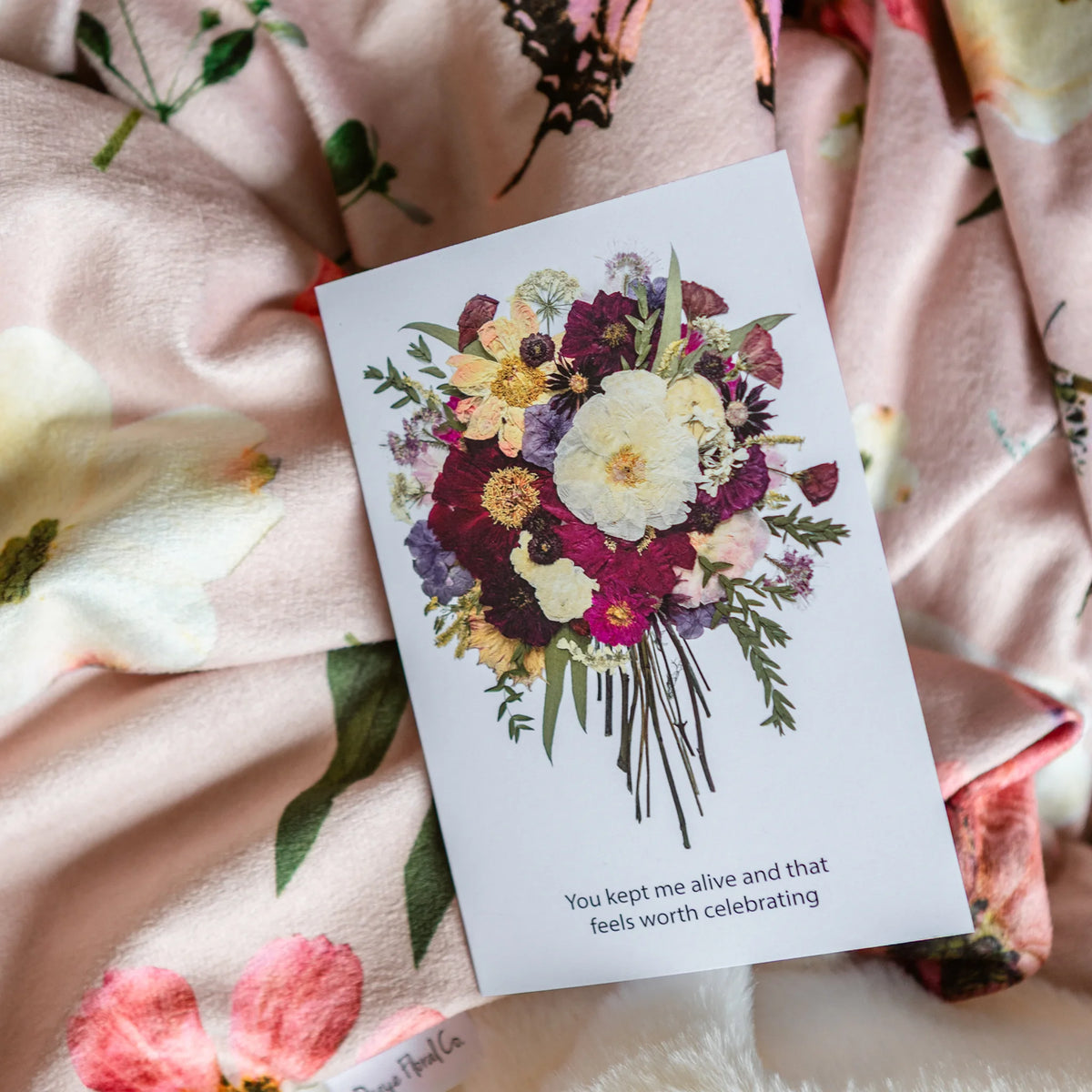Greeting card with floral design and text on a floral throw blanket