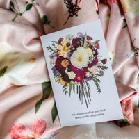 Greeting card with floral design and text on a floral throw blanket
