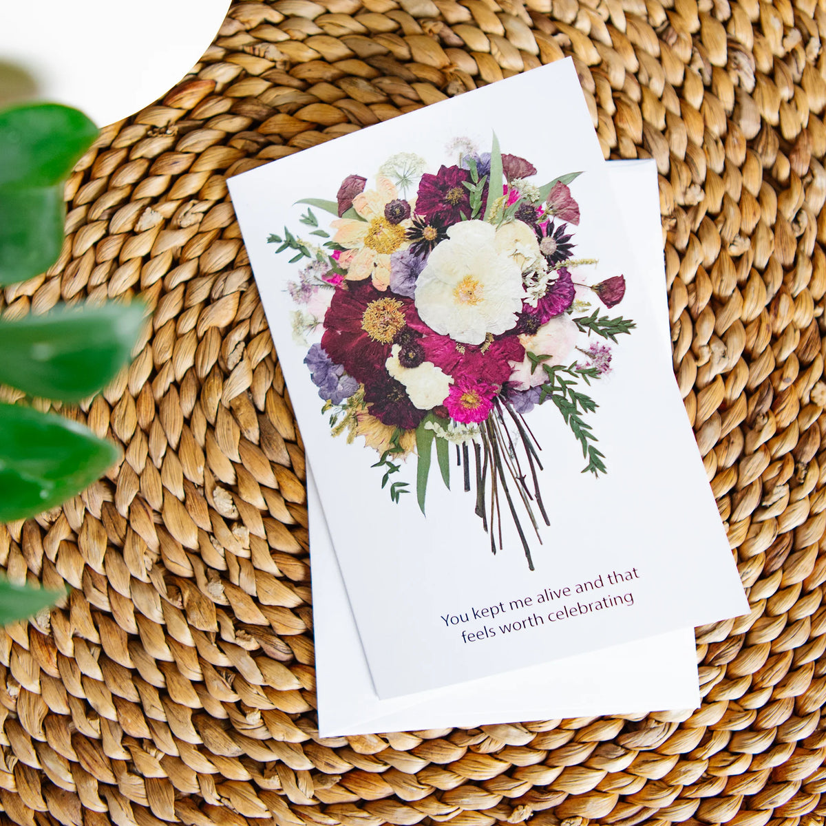 Greeting card with floral design on a woven surface
