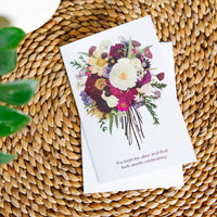 Greeting card with floral design on a woven surface