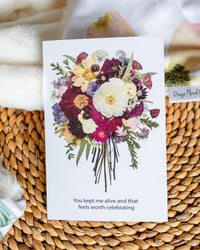 Floral card with a bouquet of flowers and text on a woven surface