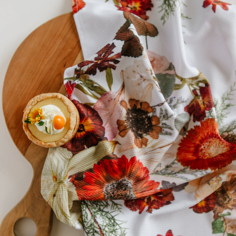 Floral-patterned towel with a small dessert on a wooden board