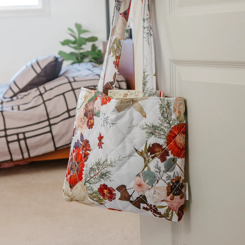 Floral patterned tote bag hanging on a white door