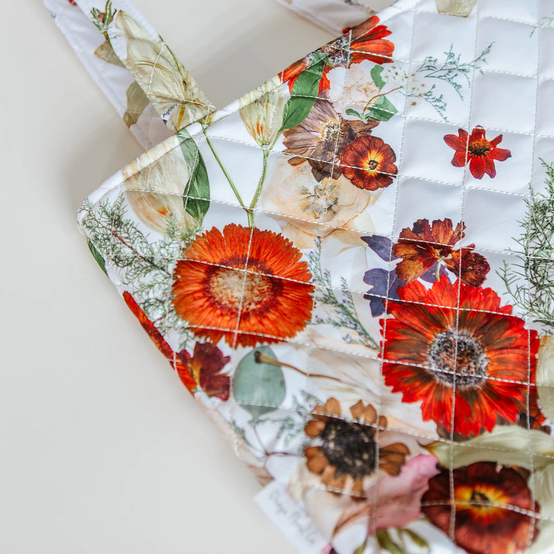 Floral patterned fabric with red and orange flowers on a white background