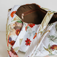 Floral-patterned bag with a brown interior on a light background
