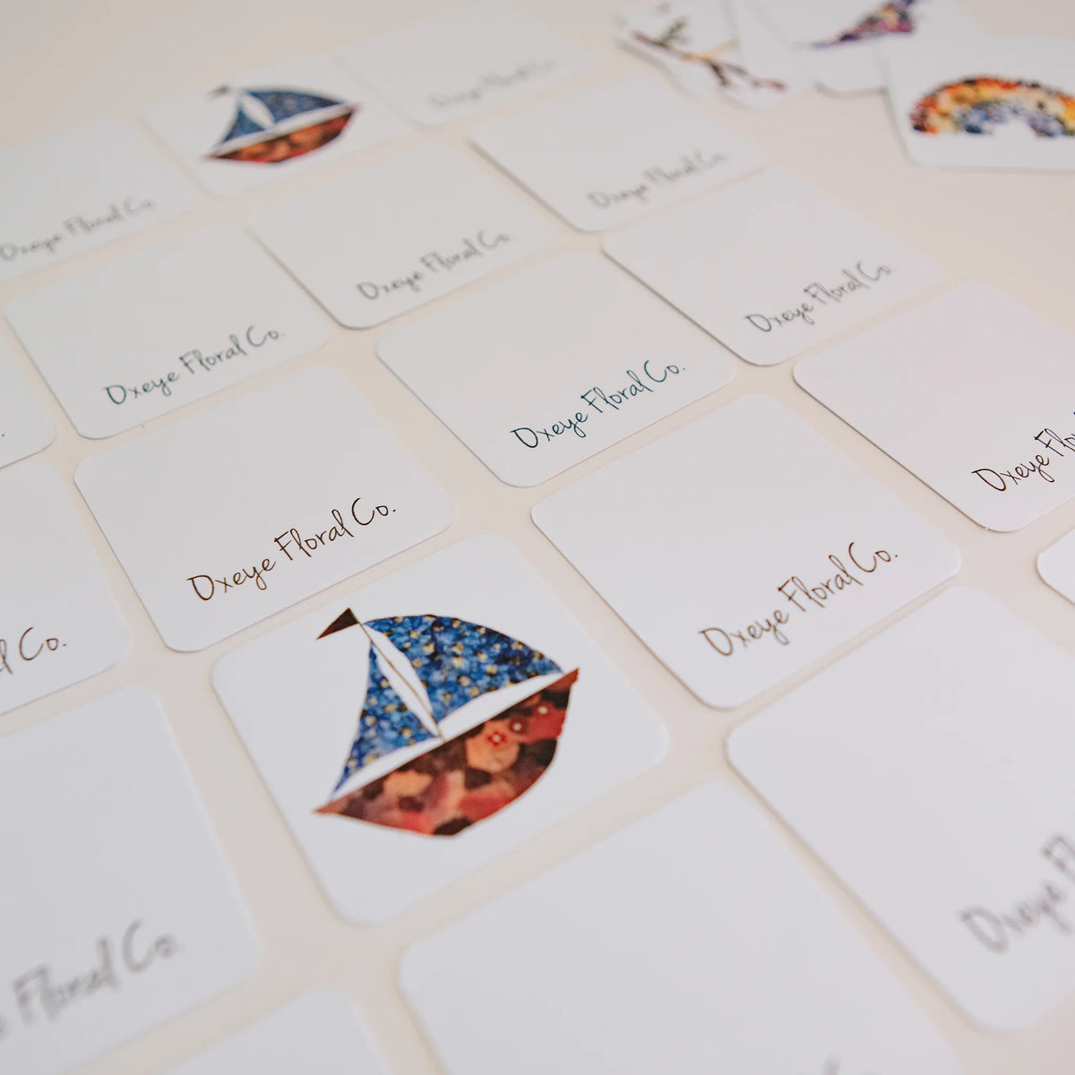 Cards with floral sailboat design and 'Oxeye Floral Co.' text on a light background
