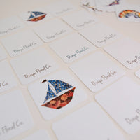 Cards with floral sailboat design and 'Oxeye Floral Co.' text on a light background