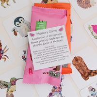 Instruction card of a memory game with floral designs on cards in the background